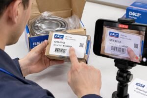 A close-up view of a technician recording an unboxing video for Scandinavia bearing return claims, focusing on the serial number label