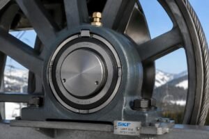 Close-up view of a large diameter spherical roller bearing installed on a ski lift main sheave, showing proper sealing and grease fitting